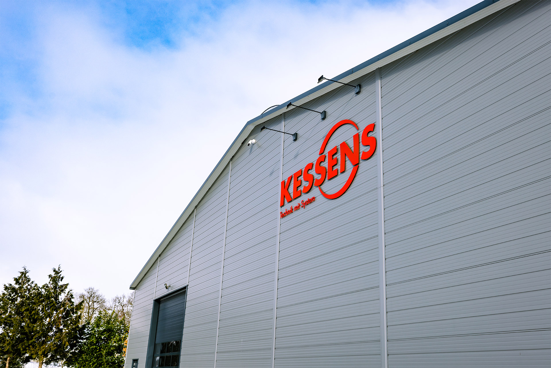 Lagerhalle von Kessens samt Logo vor blauem Himmel - Kessens Technik mit System